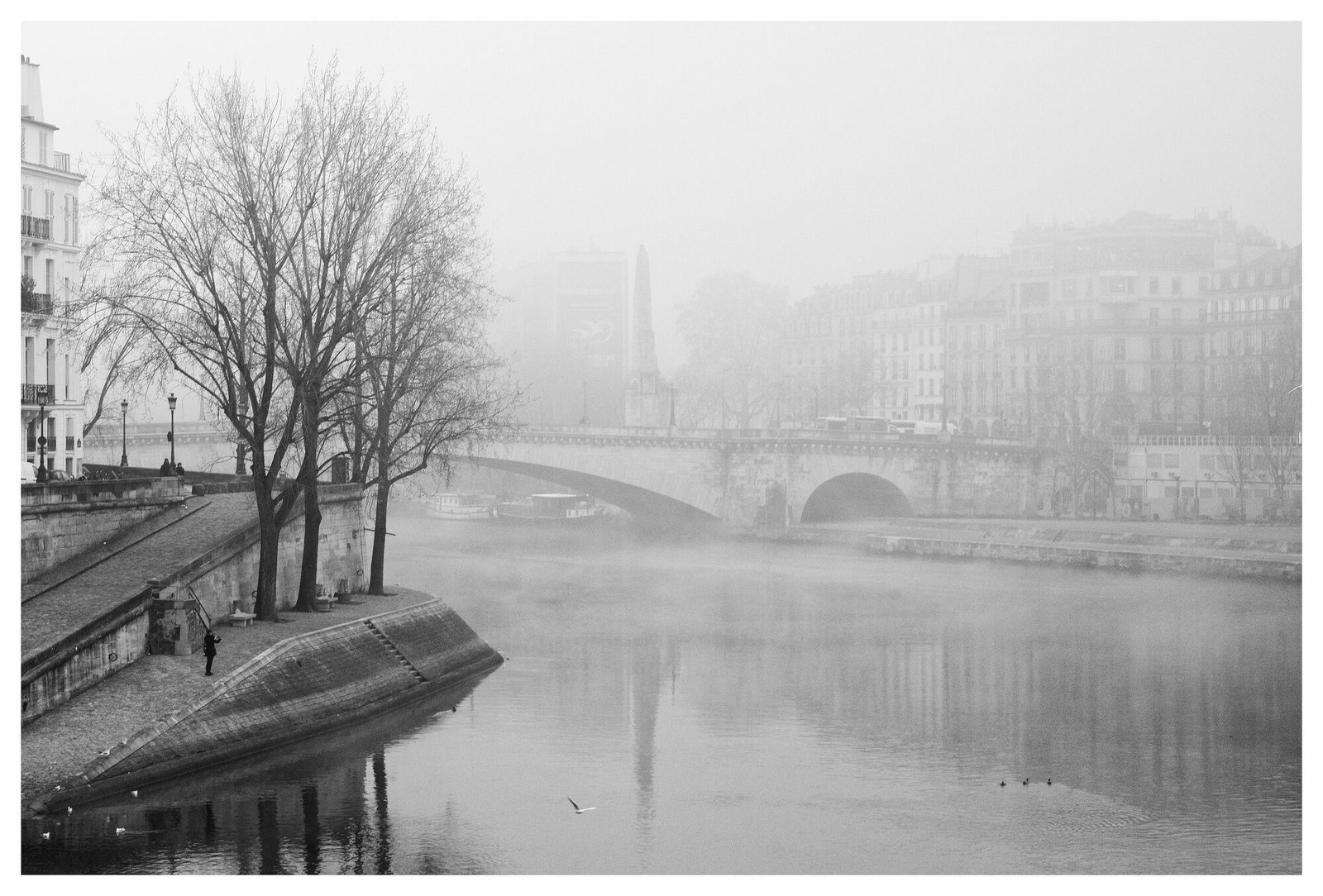 Un pont sur la Seine, à Paris, dans le brouillard, en noir et blanc.