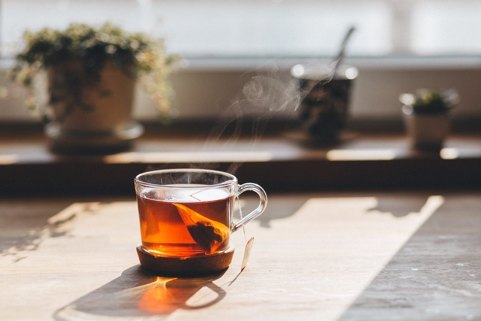 Une tasse de thé posée devant une fenêtre, dans la lumière du matin.